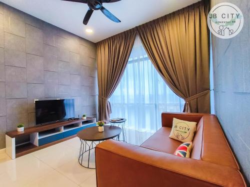 a living room with a couch and a tv at Grand Medini Suites by RR JBcity in Nusajaya