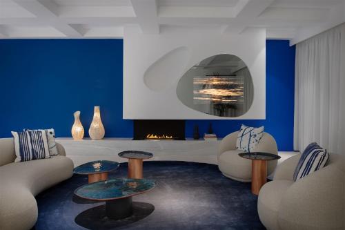 a living room with two couches and a fireplace at Mykonos Grand Hotel & Resort in Agios Ioannis Mykonos
