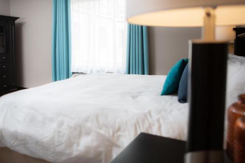 a bedroom with a white bed and a window at Monastery Hotel in St. John's