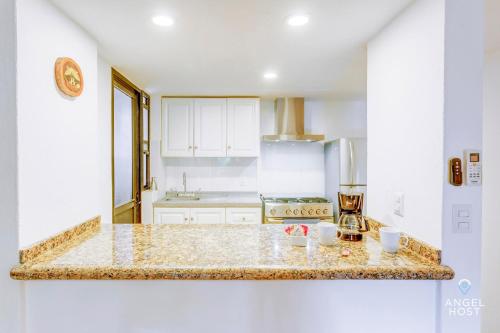 a kitchen with white cabinets and a marble counter top at Private Villa Complex with Pool in Zona Hotelera in Cancún