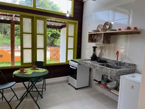 uma cozinha com um lavatório e uma mesa em Chalés Mata da Praia Corumbau em Corumbau