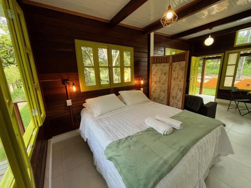 um quarto com uma cama com duas toalhas em Chalés Mata da Praia Corumbau em Corumbau