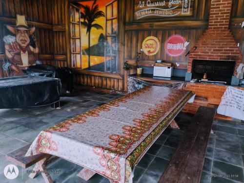 a wooden bench in a room with a wall at Colônia Virtual Net in Itanhaém
