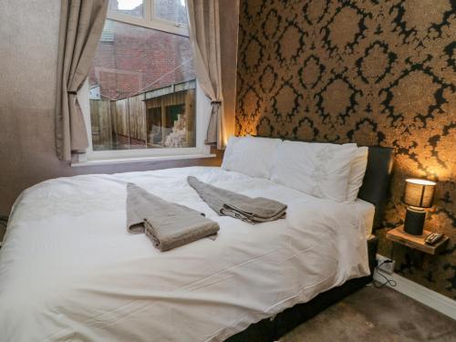 布里德靈頓的住宿－Cosy Coastal Holiday Let，一张带两个枕头的白色床和窗户