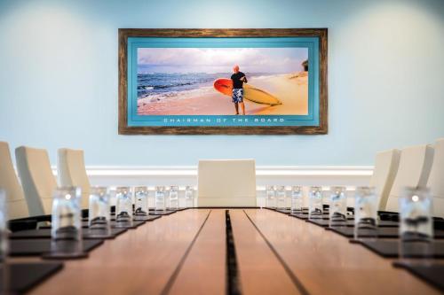 a conference room with a man holding a surfboard on the beach at Margaritaville Beach Resort South Padre Island in South Padre Island