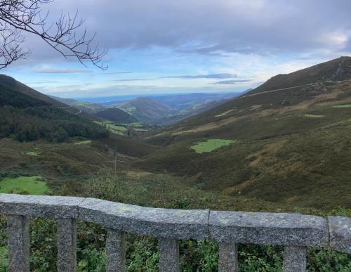 a view of a mountain valley from a stone bench at Ahío San Martín, Apartamentos Rurales Casa de la Villa in San Martín de Oscos
