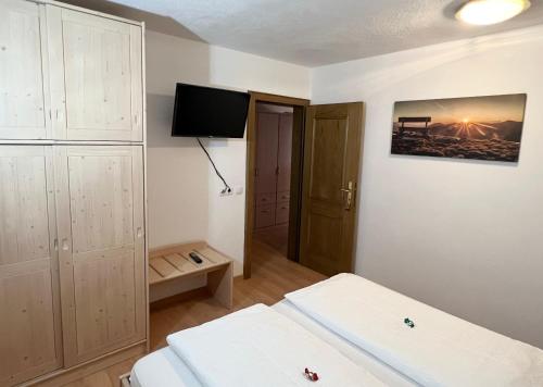 a room with two beds and a television in it at Residence Vajolet San Cassiano in San Cassiano