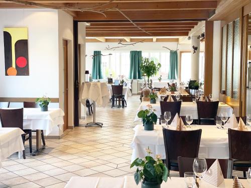 a dining room with white tables and chairs and tablesktop at Hotel Restaurant Sternen in Gelfingen