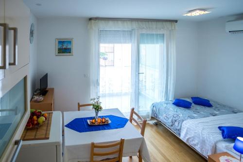 Cette petite chambre comprend un lit, une table, un lit et une fenêtre. dans l'établissement Studio Teuta, à Split