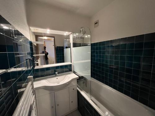 a bathroom with a tub and a sink and a mirror at Appartement Lanslebourg-Mont-Cenis, 2 pièces, 5 personnes - FR-1-508-40 in Lanslebourg-Mont-Cenis