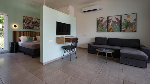 a living room with a couch and a bed at Blue Bay Lodges in Willemstad