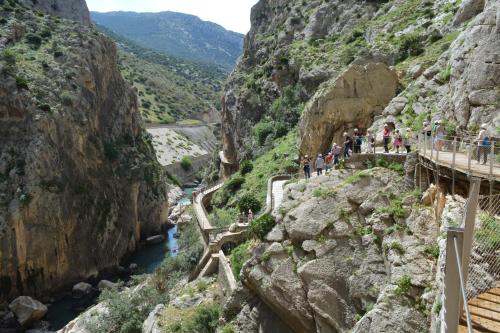 people walking on a bridge over a river in a canyon at Apartamento Trinidad Grund in Ardales