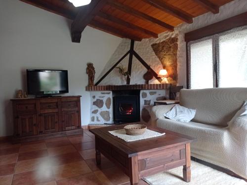 a living room with a couch and a fireplace at Casa Rural El Turuterro in Cepeda