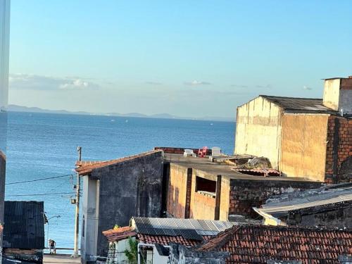 a group of buildings with the ocean in the background at Apartamento encantador em salvador in Salvador