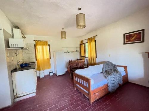 a bedroom with a bed and a kitchen with a refrigerator at CABAÑAS LA PILARICA in San Rafael