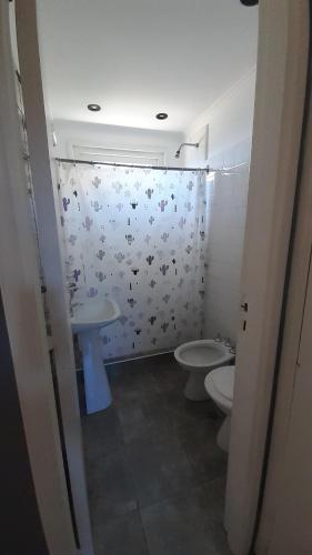 un baño con dos aseos y una cortina de ducha en el Hotel Acuarium de Villa Gesell