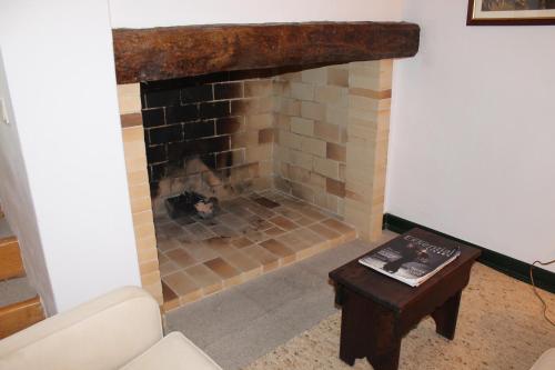 a living room with a brick fireplace with a table at Casa de Viana do Alentejo in Viana do Alentejo