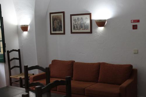 a living room with a couch and two pictures on the wall at Casa de Viana do Alentejo in Viana do Alentejo
