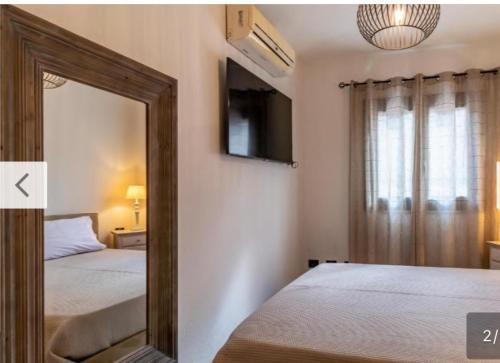 ヴァッレドーリアにあるResidence valledoria2のベッドルーム(ベッド2台、テレビ付)の鏡