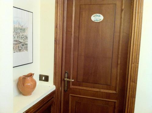 a wooden door in a room with a vase on a shelf at Hotel Pallotta in Assisi