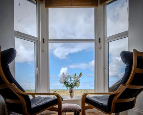 two chairs in front of a window with a view at Bellaview Apartment Barmouth in Barmouth