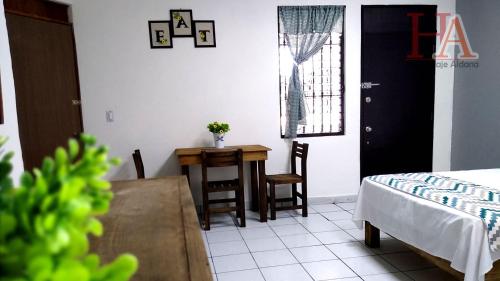 Zimmer mit einem Tisch, einem Tisch und einem Bett in der Unterkunft Hospedaje Aldana - Posada SOL en zona natural in Tuxpan de Rodríguez Cano