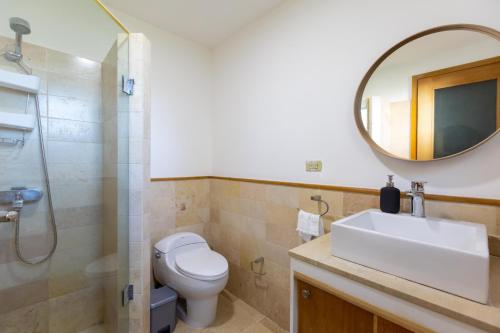 La salle de bains est pourvue de toilettes, d'un lavabo et d'un miroir. dans l'établissement Cap Cana 3br Full Kitchen, Wifi, Smart Check-in, à Punta Cana