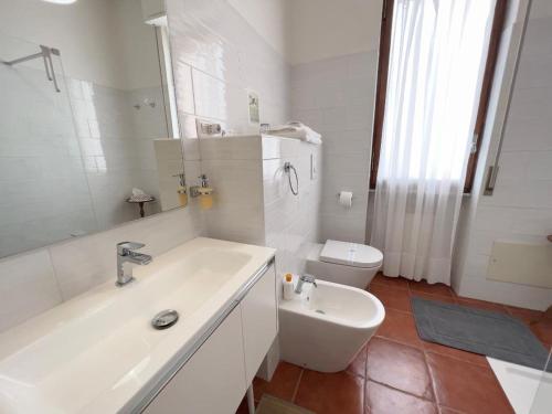 a white bathroom with a sink and a toilet at La terrazza di Anna in Sassari