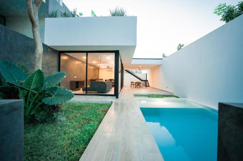 - une vue extérieure sur une maison avec une piscine dans l'établissement Saria 7C Temozón, à Mérida