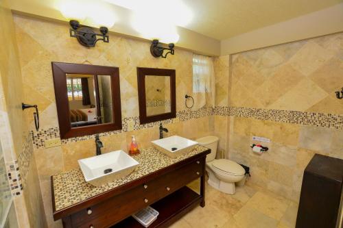 a bathroom with two sinks and a toilet at Caribbean Shores Belize in Hopkins