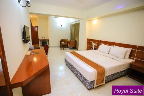 Habitación de hotel con cama y escritorio en Royal Beach Resort, en Cox's Bazar