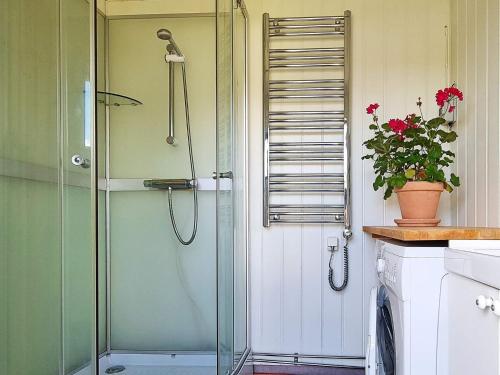 La salle de bains est pourvue d'une douche avec une porte en verre. dans l'établissement Holiday home SÄFFLE IV, à Säffle