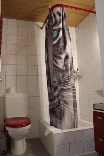 a bathroom with a toilet and a shower curtain at The Engstligen in Adelboden