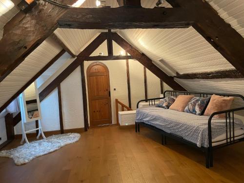 1 dormitorio con 1 cama en el centro de un ático en La Bureliere- Holiday home for families, groups and couples, en Gorron