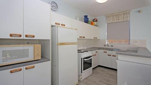 a kitchen with white appliances and white cabinets at Headlands 2 in Port Macquarie