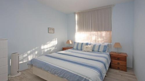 a bedroom with a large bed with a window at Headlands 2 in Port Macquarie