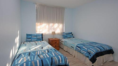 two twin beds in a room with a window at Headlands 2 in Port Macquarie