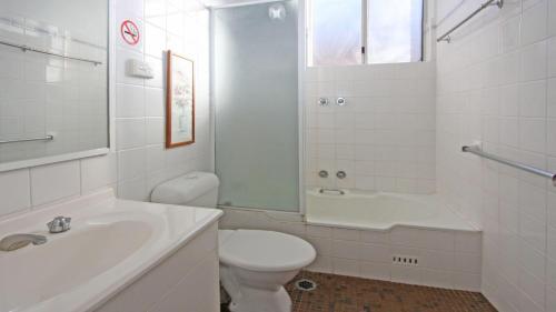 a white bathroom with a toilet and a sink at Headlands 2 in Port Macquarie