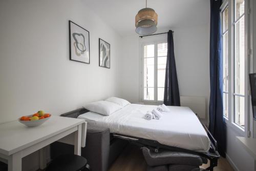 Cette chambre comprend un lit et un bureau avec une corbeille de fruits. dans l'établissement 5#Studio 2Pers#Paris 15#Commerce#AC, à Paris