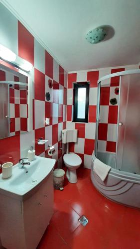 a red and white bathroom with a toilet and a shower at Casa Aly Bușteni- Casa la cheie in Buşteni