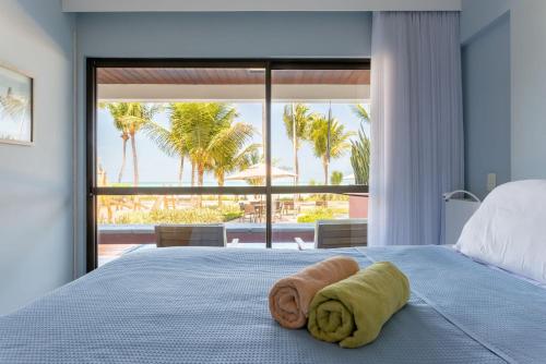 a bedroom with a bed with a towel on it at Paraíso a Beira Mar de Porto de Galinhas in Porto De Galinhas