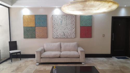 a living room with a couch and paintings on the wall at Quinta Manuela in Mendoza