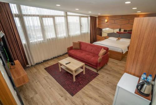 uma sala de estar com um sofá vermelho e uma cama em HİLL SUİTES em Istambul