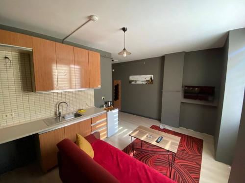 uma sala de estar com um sofá vermelho e uma cozinha em HİLL SUİTES em Istambul