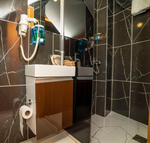Un baño con lavabo y ducha con espejo. en 216 Hill Suites, en Estambul