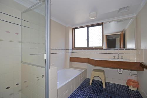a bathroom with a tub and a sink and a shower at Quarterdeck 9 in Port Macquarie