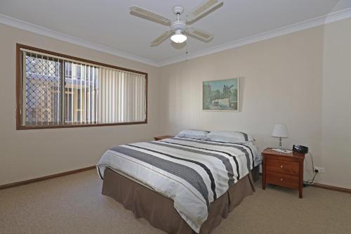a bedroom with a bed and a ceiling fan at Quarterdeck 9 in Port Macquarie