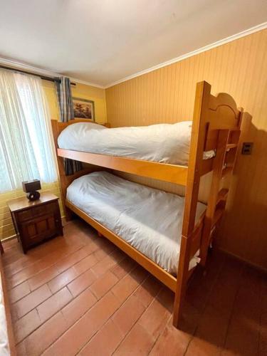 Cabaña Algarrobo في ألغاروبو: غرفة نوم بسريرين بطابقين في غرفة