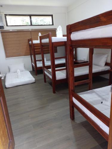 a room with several bunk beds and a table at Villa Marilyn Resort and Hotel in Coron