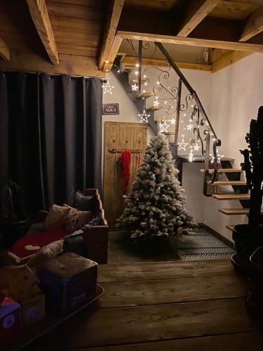 a living room with a christmas tree and a staircase at L'instant présent in Echallon